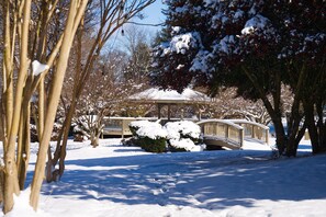 A gazebo with a snow-covered roof, surrounded by snow-laden trees and a wooden bridge. - Tremont Lodge & Resort (Townsend)