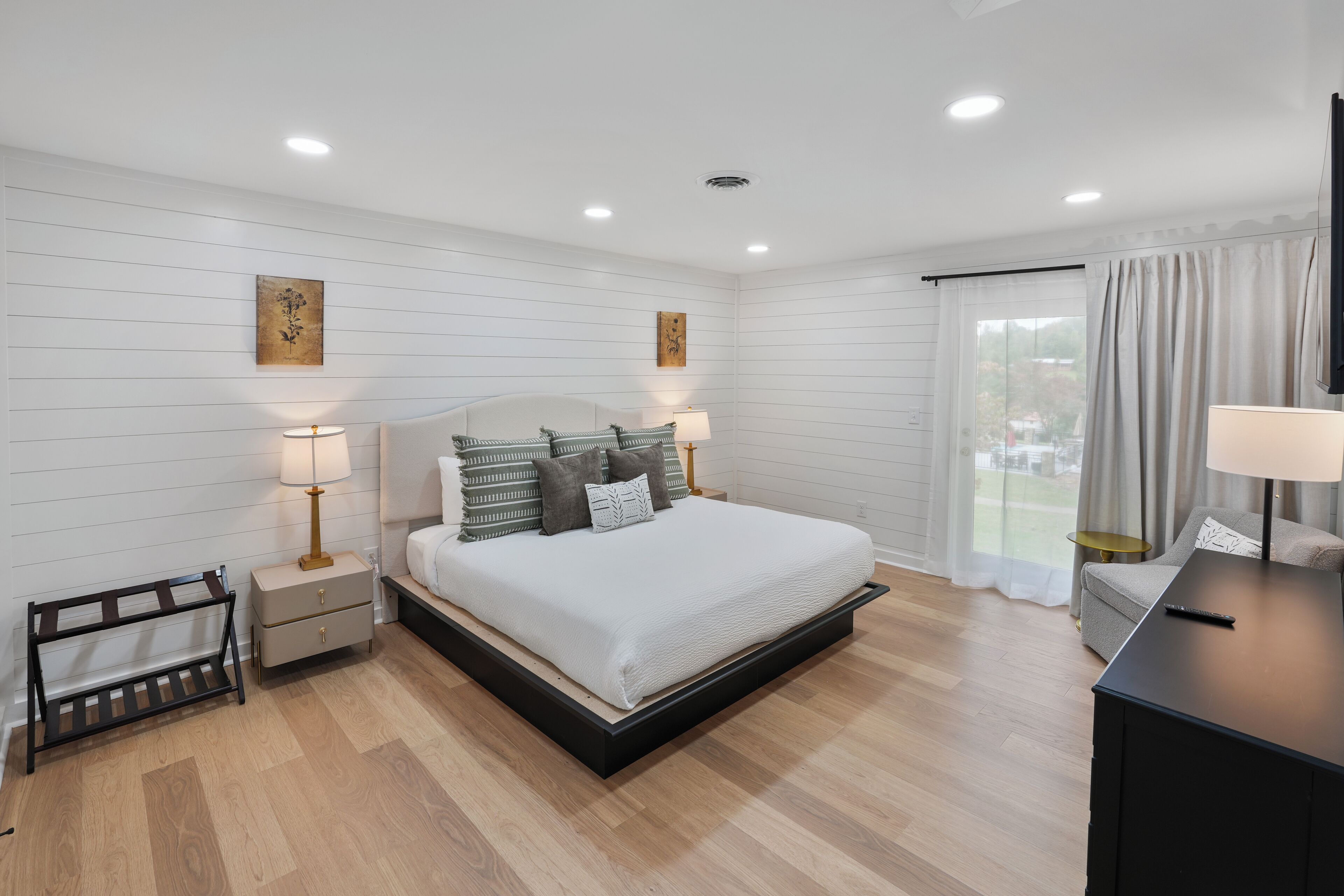 Une chambre à coucher moderne, avec un lit, des tables de chevet et un téléviseur.