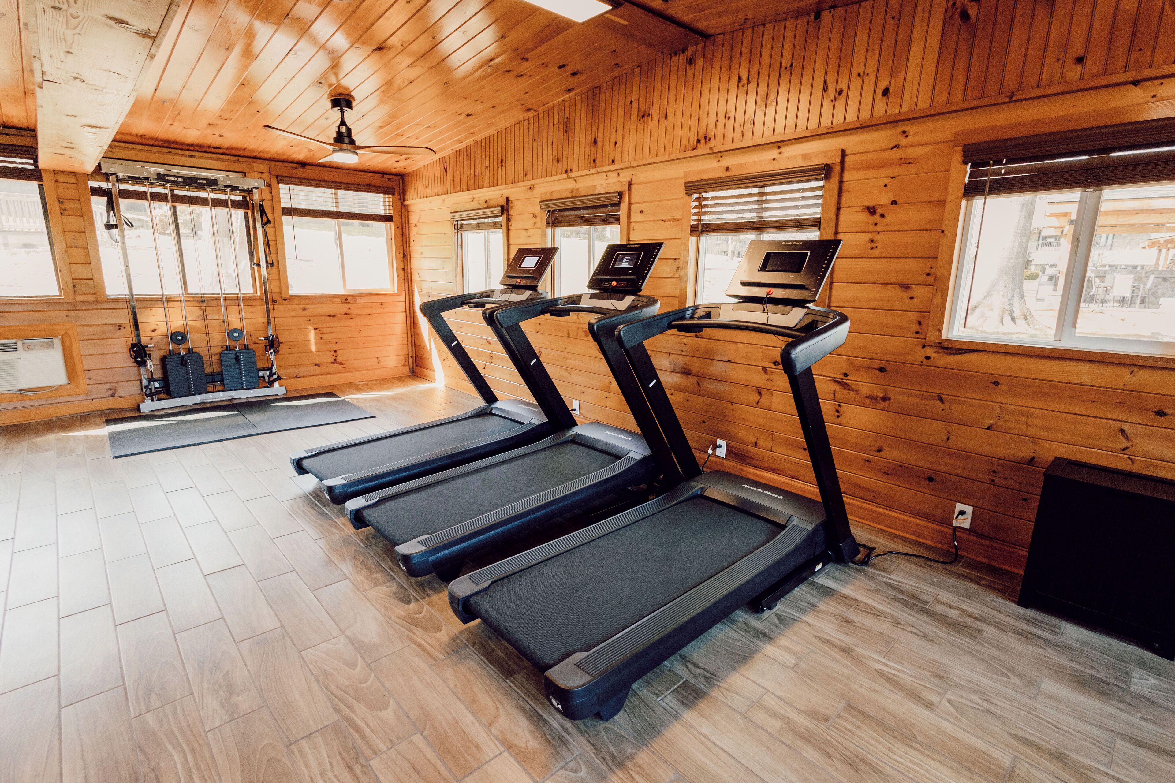 Un interior de madera con cuatro cintas de correr y un ventilador de techo.