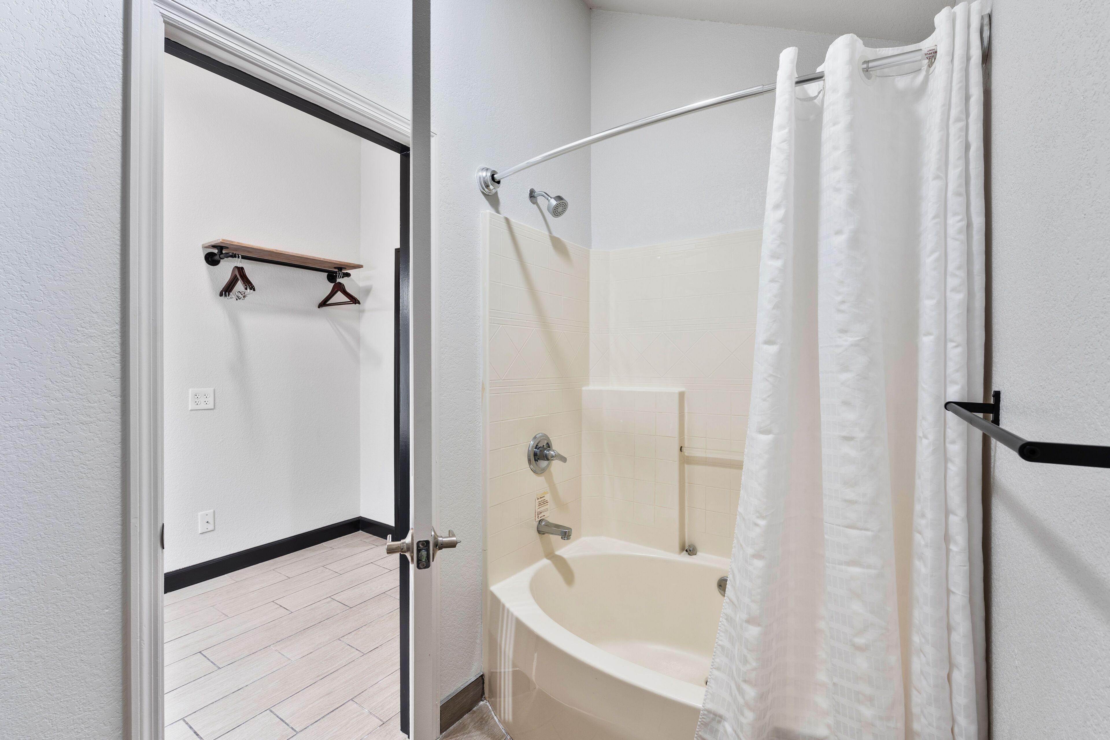 Une salle de bain avec une baignoire, un rideau de douche et un porte-serviettes.