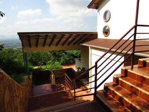A staircase leading to a covered outdoor area with a view of the landscape. - Edelwyss-Inn (Morogoro)
