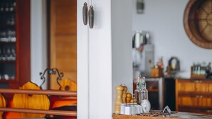 Un intérieur rustique avec une table à manger en bois, des chaises et une horloge fixée au mur.