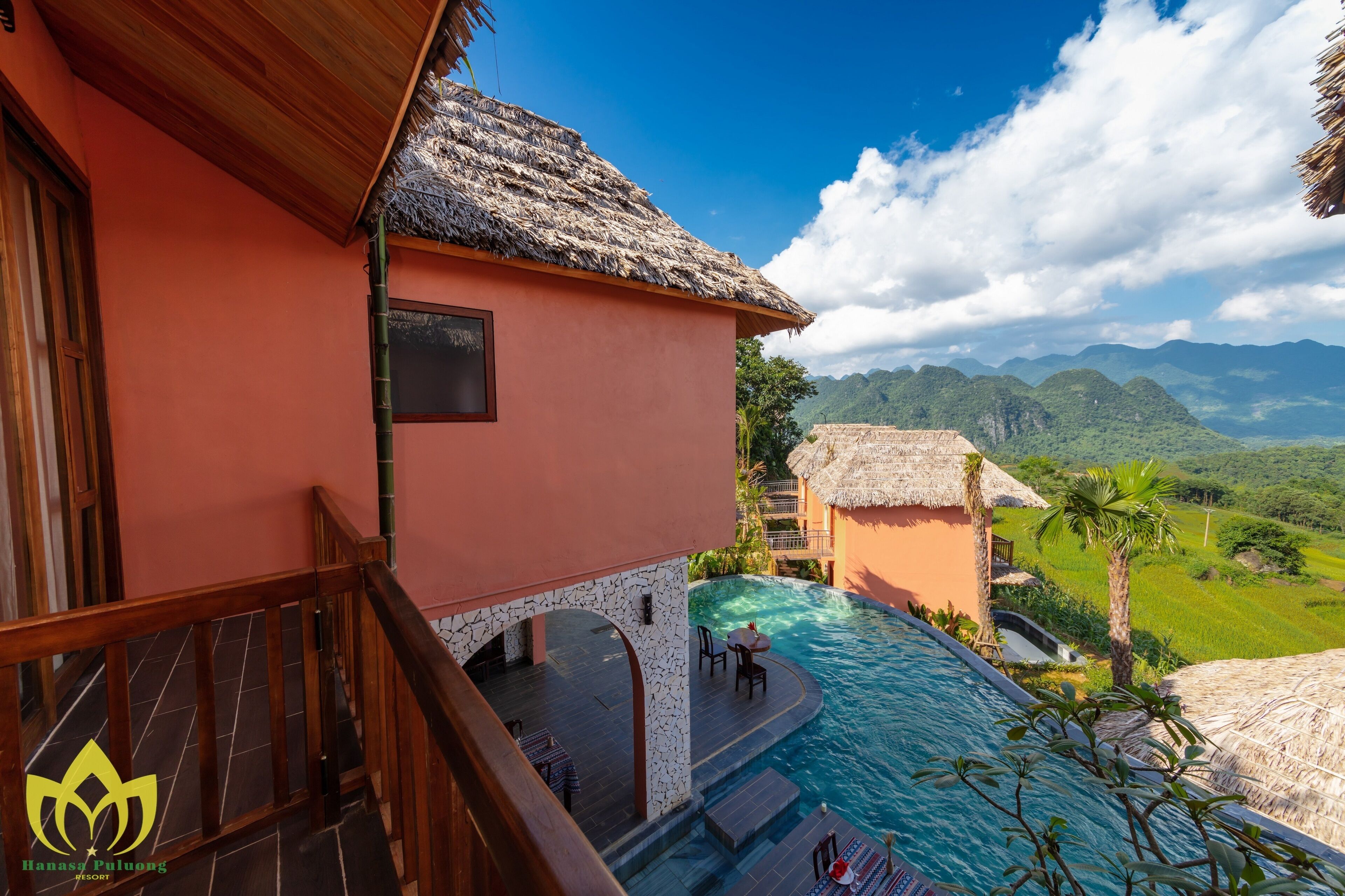 Un complexe hôtelier doté d’une piscine, d’une terrasse en bois et offrant une vue sur les montagnes.
