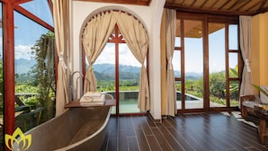 Un baño con bañera, ducha y vistas a las montañas.