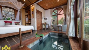 Un dormitorio con una cama grande, una piscina pequeña y vistas al exterior.