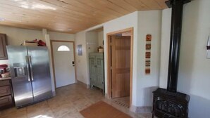 Eine Küche mit einem Edelstahl-Kühlschrank, Holzschränken und einer Holzbalkendecke.