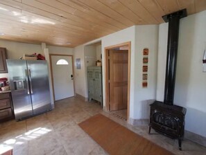Enjoy cooking in this well-equipped kitchen with a refrigerator, wooden cabinet, and comfortable bench.