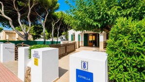 Eine Villa namens 'Villa Estrella' mit befestigtem Zugang, einem Holzzaun und üppiger Bepflanzung.
