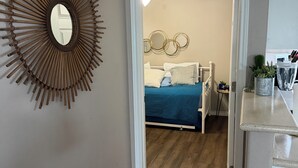 A bedroom with a bed, a wall-mounted mirror, and a circular wall decoration. - TRANQUILITY BAY-Spring /Summer /WINTER TEXAN FAVORITE!!  Come RELAX with us! (Aransas Pass)