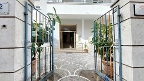 A gated entrance with a tiled pathway leading to a building entrance. - Comfy apartment next to Vatican city (Roma)