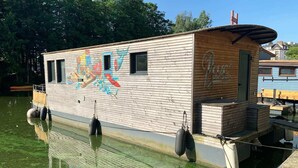 Un bote de madera con un mural, amarrado en un muelle.