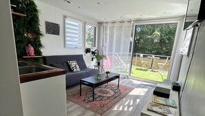 Una sala moderna con un sofá, una mesa de centro y vistas al exterior.