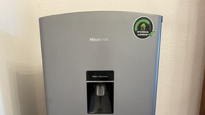 A Hisense water dispenser in a corner with a tiled floor.