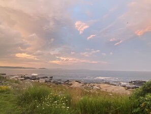 A coastal landscape with rocky terrain and a view of the sea.