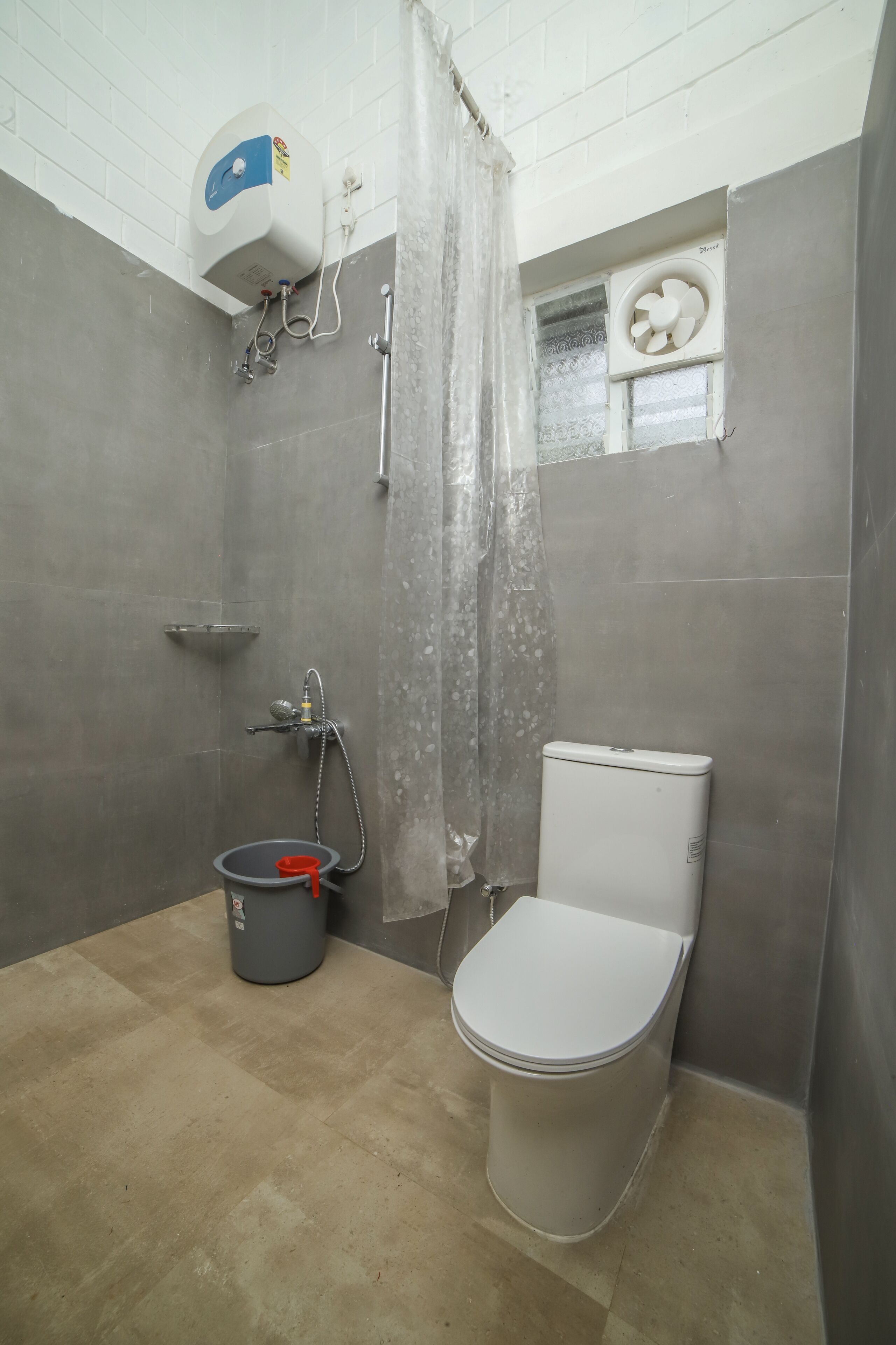 A bathroom with a toilet, shower, and a water heater.