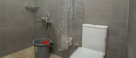 A bathroom with a toilet, shower, and a water heater.