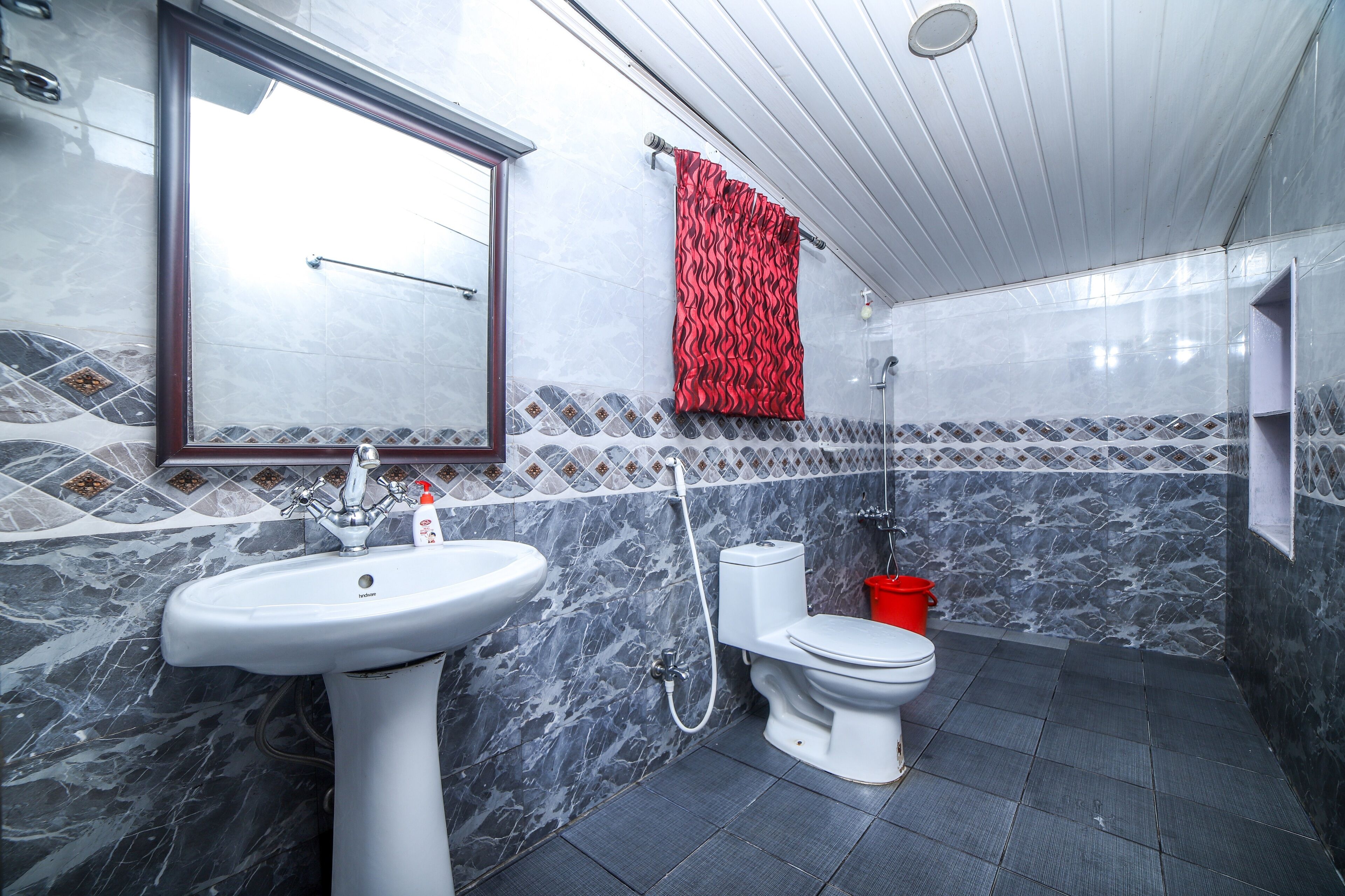 Une salle de bain avec un lavabo blanc, des toilettes et une douche.