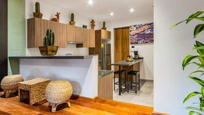Una cocina moderna con armarios de madera, una isla central y taburetes de bar.