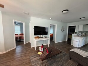 A modern living room with a flat-screen TV, a coffee table with a fire extinguisher, and a sofa. - TEQUILA SUNRISE - A Summer & WINTER TEXAN FAVORITE! Come relax with us. (Aransas Pass)