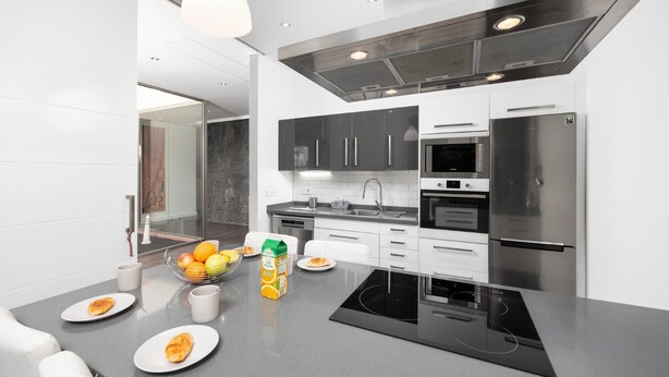 A modern kitchen with a central island, stainless steel appliances, and a minimalist design.