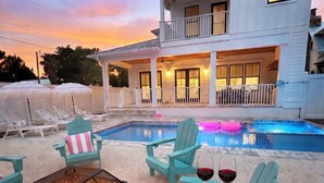 A poolside area with lounge chairs, a fire pit, and a table with drinks and marshmallows. - Luxe 5BR with Pool, Hot Tub, Outdoor Kitchen, Bikes, Close to Beach & Seaside (Santa Rosa Beach)