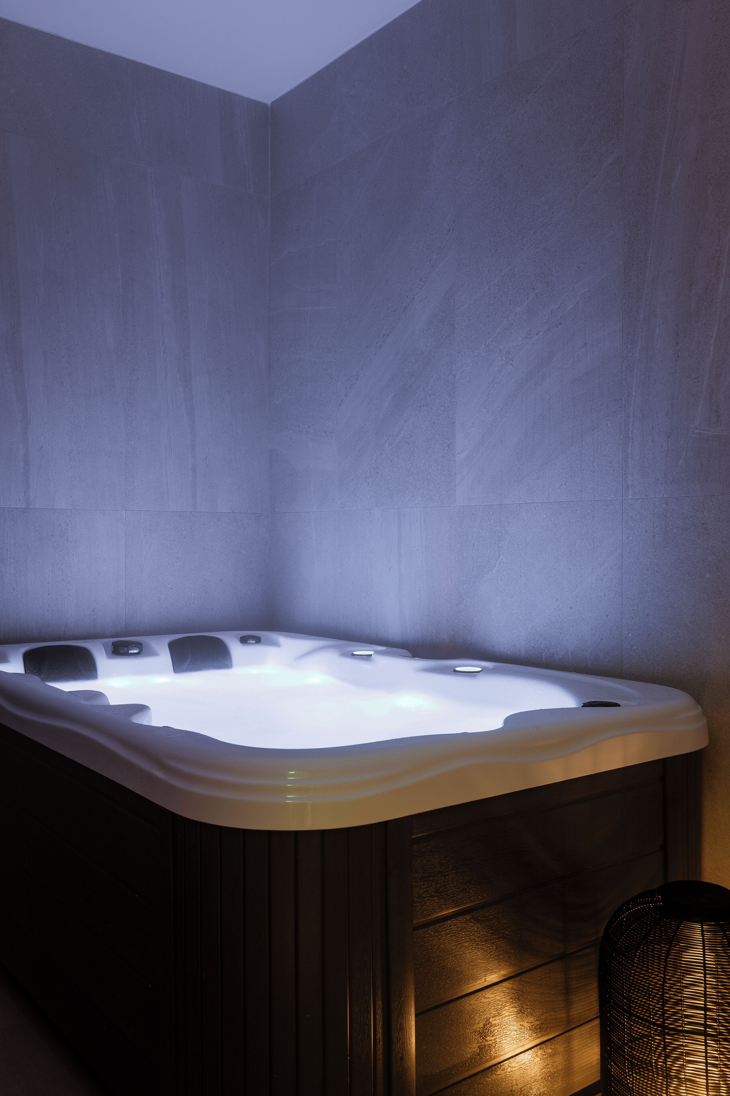 Ein modernes Badezimmer mit einer freistehenden Badewanne, Holzverkleidung und einer strukturierten Wand.