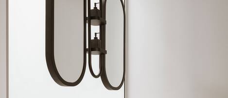 Een moderne badkamer met een grote spiegel, twee ronde wasbakken en een minimalistisch design.