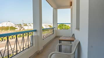 Un balcón con vista a edificios, una mesa y dos sillas.