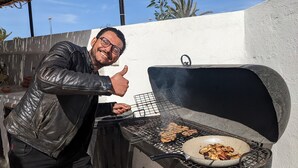 A man giving a thumbs-up next to a barbecue grill with food being cooked. - Cozi Coliving (Mezraia)