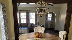 A dining area with a round wooden table, four upholstered chairs, and a decorative centerpiece.