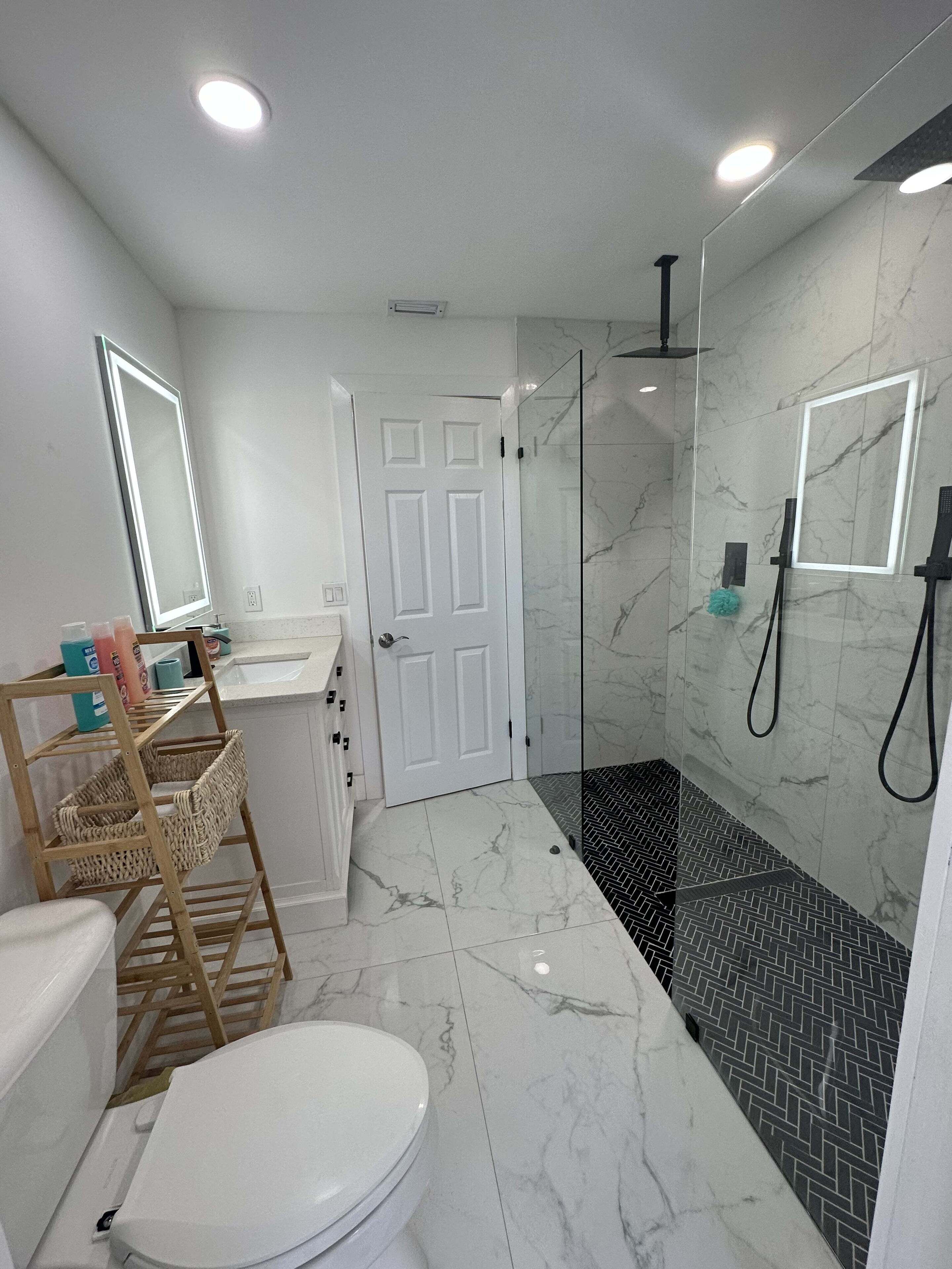 A modern bathroom with a toilet, sink, and shower area.