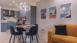 Una cocina moderna con comedor, que presenta una araña, un sofá y obras de arte en la pared.