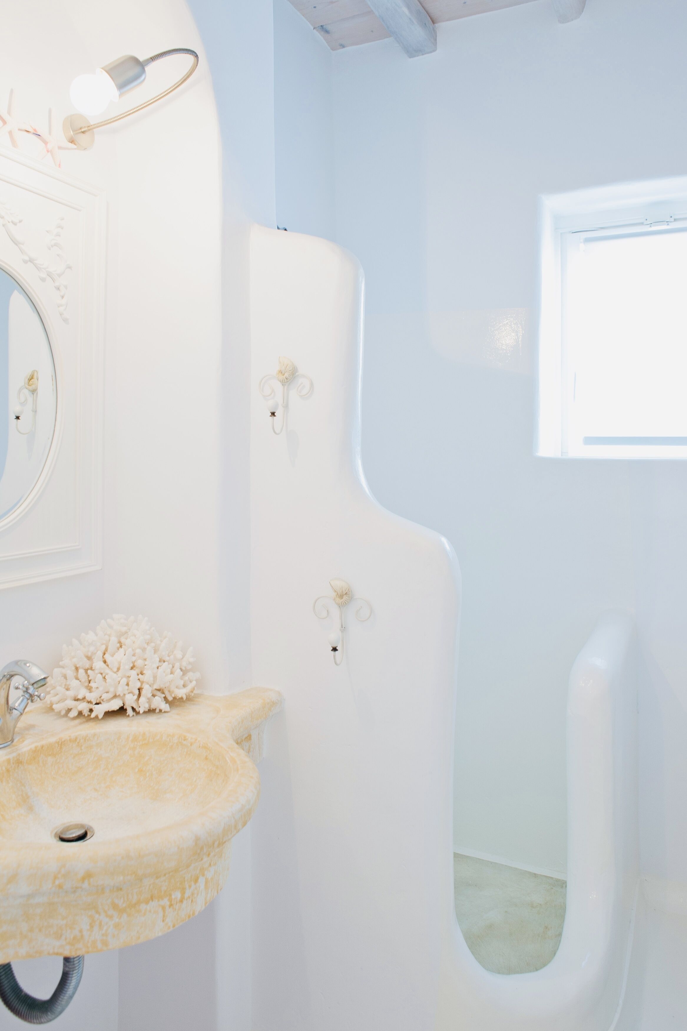 A bathroom with a white sink, a mirror, and a toilet.