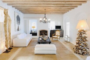 A spacious living room with a white sofa, a coffee table, and a fireplace.