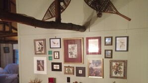 Una stanza con una scrivania in legno, quadri appesi al muro e un tappeto rosso sul pavimento.