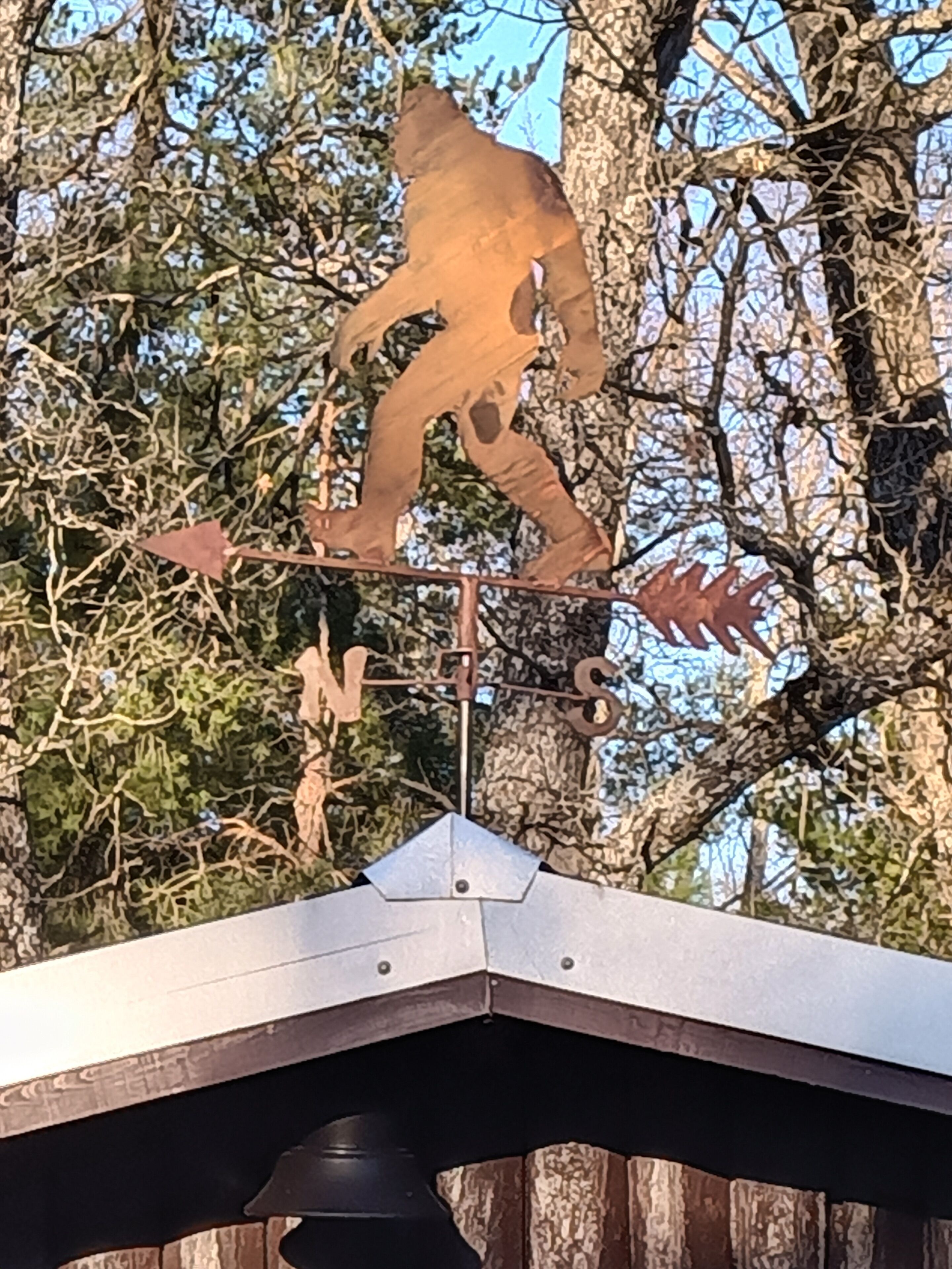 Eine Metallskulptur eines Bären auf einem Ast.