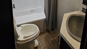 Ein kleines Badezimmer mit Dusche, Toilette und Waschbecken.