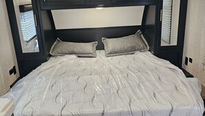 Ein Bett mit Kopfteil, zwei Kissen und einer Matratze.