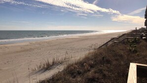 A beach with a wooden boardwalk leading to a building. - Updated OCEANFRONT Queen's Grant 3 Bedroom-Pool, Boat Ramp, Dock, Sleeper Sofa (Topsail Beach)