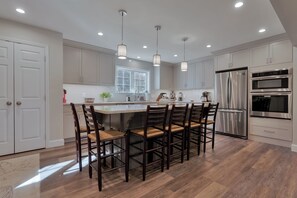 A modern kitchen with a central island, stainless steel appliances, and pendant lighting. - Rock Haven Lake Vacation Rental | Peaceful Waterfront Escape with Dock, Kayaks & Pet-Friendly Comfort (Newfield)