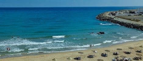 En la playa, camastros, sombrillas y toallas de playa 