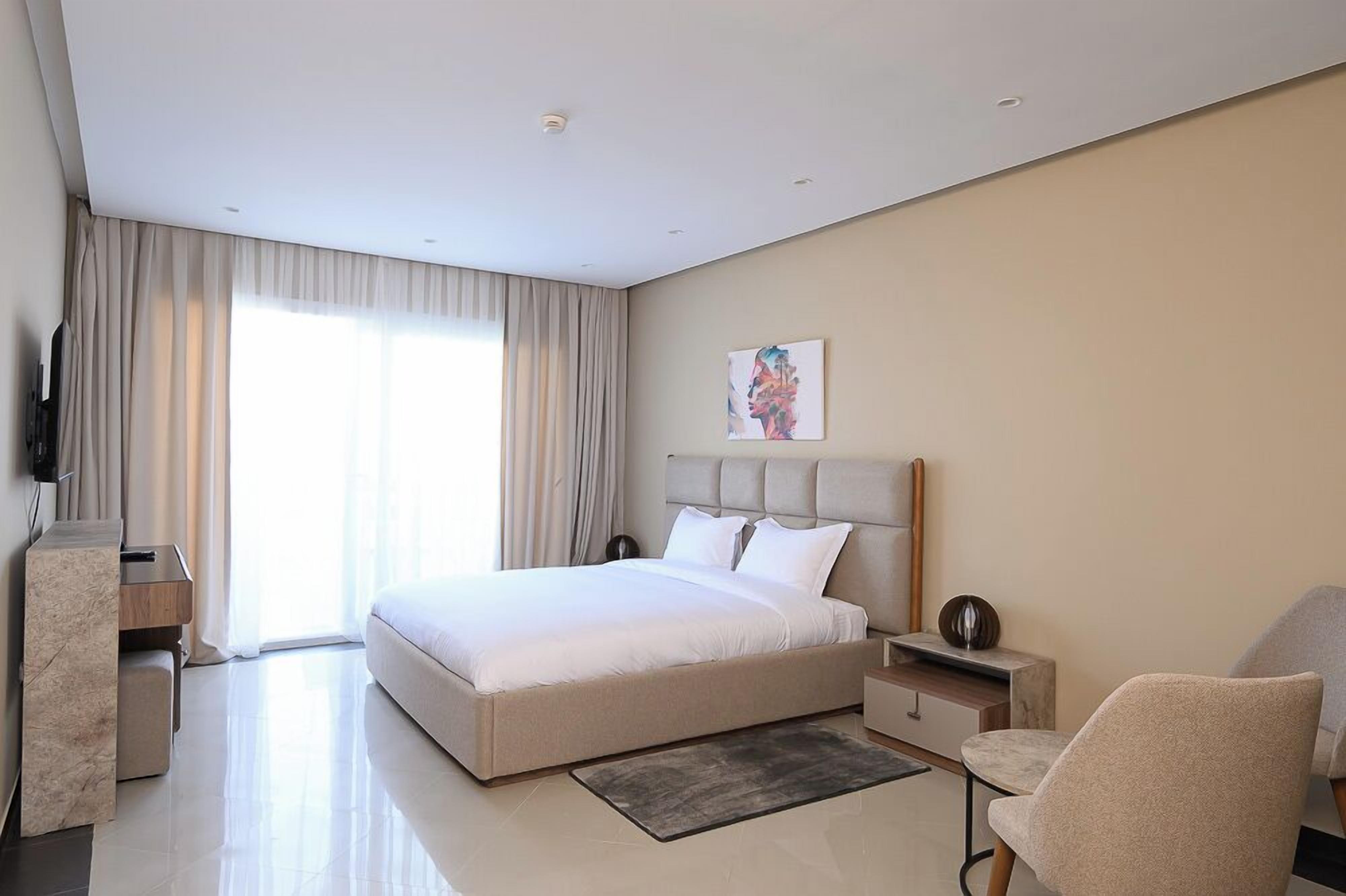 Una moderna camera d'albergo con un letto grande, una scrivania, una sedia e una televisione.