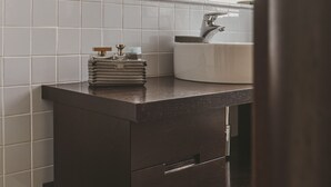 A modern bathroom with a dark wooden vanity, a white sink, and a mirror above the vanity. - San Pietro Cozy And Quiet Three-room Apt (Rome)