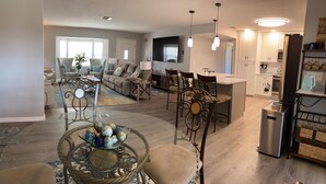 A spacious living room with a dining area, a kitchen, and a seating area with a large window. - Serenity now, full refund*, pool heat, sleeps 8 (Rotonda West)
