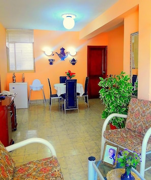 Enjoy meals in the dining area with a table and chairs, a small table with a vase, and a potted plant.