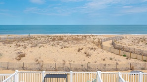 A beach view with a wooden fence, a bench, and a clear sky. - Beautiful Direct Ocean Front Townhome in Sea Village with Relaxing Ocean Views! (Ocean City)