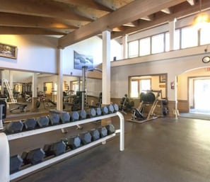 A gym with weightlifting equipment, mirrors, and a large window. - Luxury Northstar Ski Cabin • Free Shuttle to Lifts • Fireplace • Xbox • Hot Tub (Truckee)