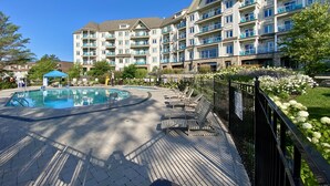 Un hôtel à plusieurs étages doté d’une piscine, d’un espace extérieur aménagé et d’un jardin bien entretenu.