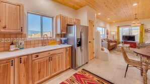 Una cocina moderna con gabinetes de madera, un refrigerador de acero inoxidable y una ventana con vistas panorámicas.