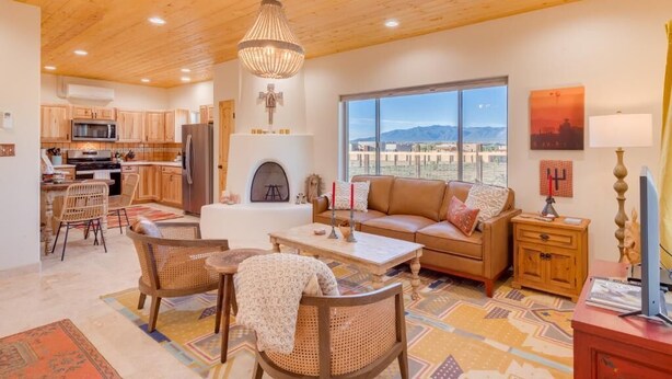 Un amplio salón con chimenea, un sofá y una mesa de comedor.